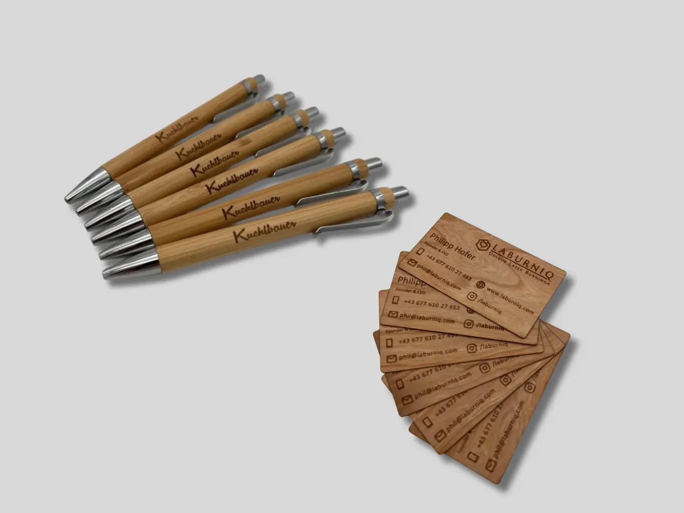 Kugelschreiber und Visitenkarten aus Holz auf einem Schreibtisch